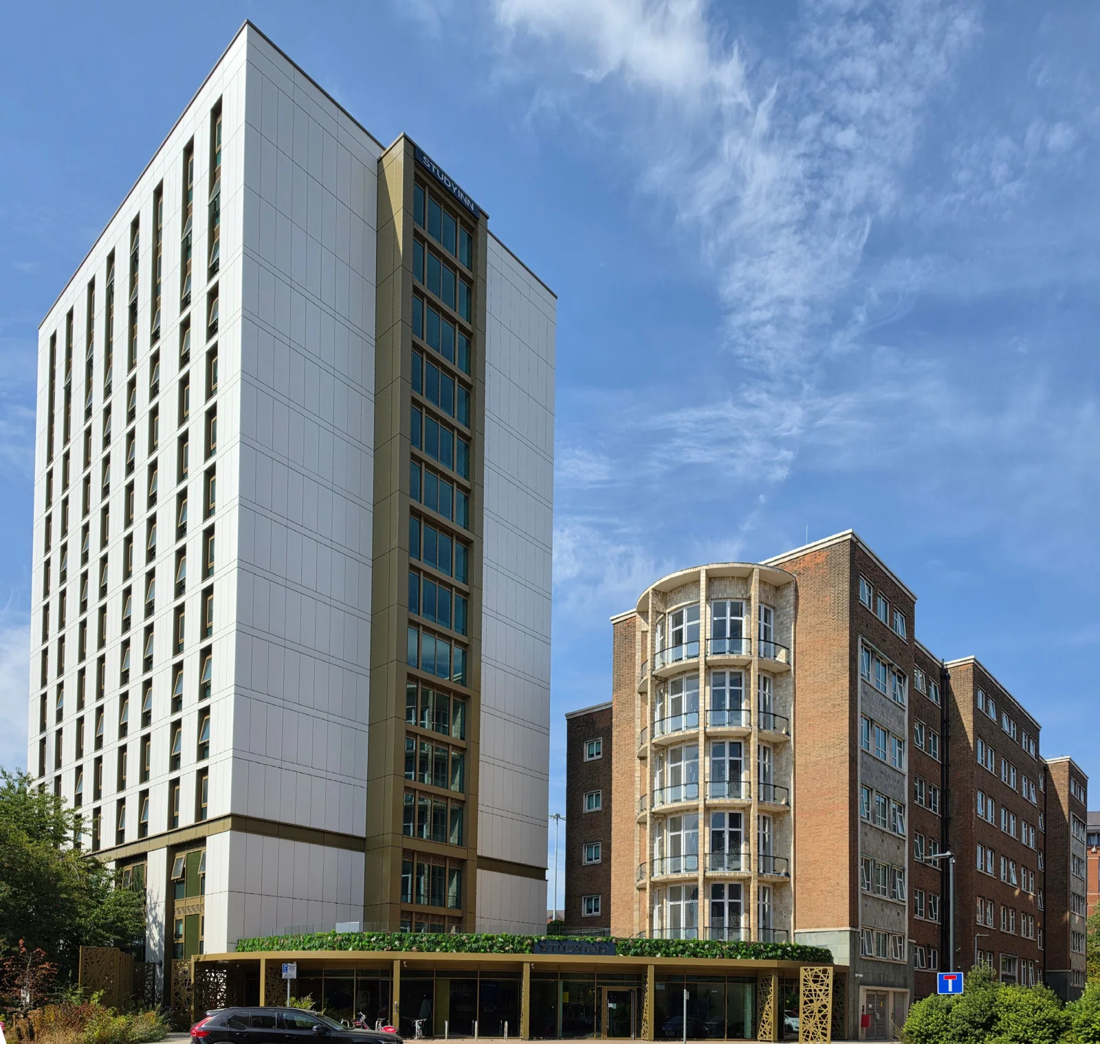 Brotherton House and its student accommodation tower in Leeds under a blue sky.