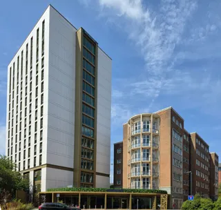 Brotherton House and its student accommodation tower in Leeds under a blue sky.